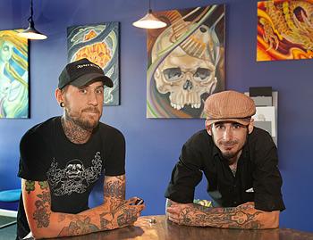 Tattoo artists standing at a counter