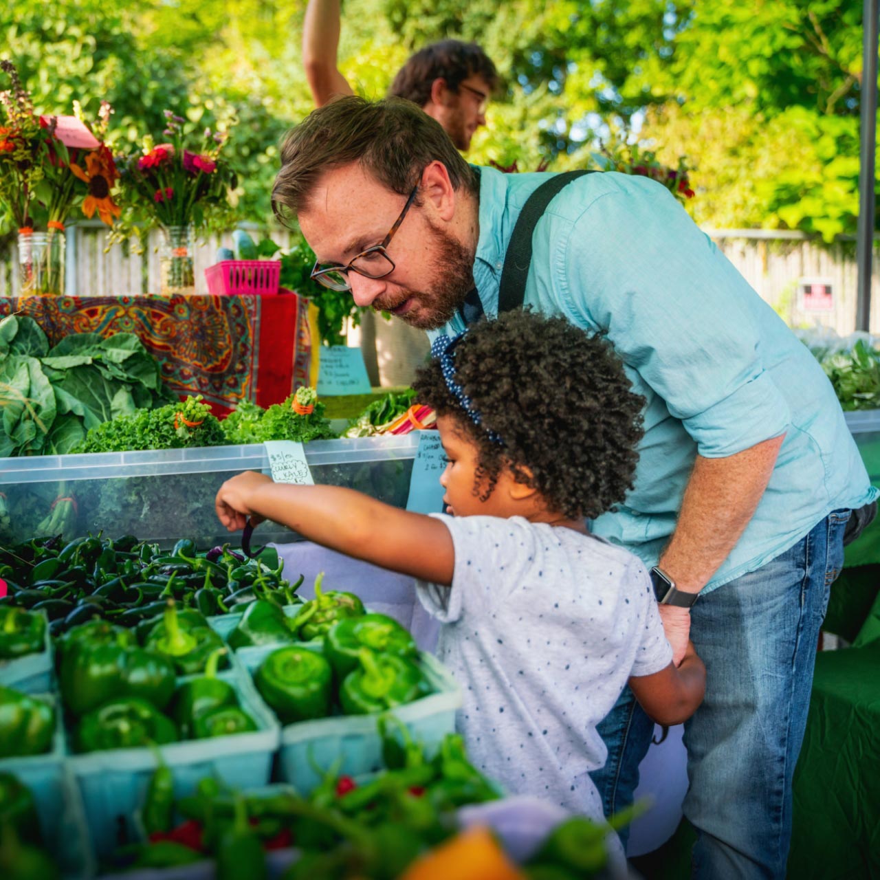 Adult and child shopping at an outdoor market