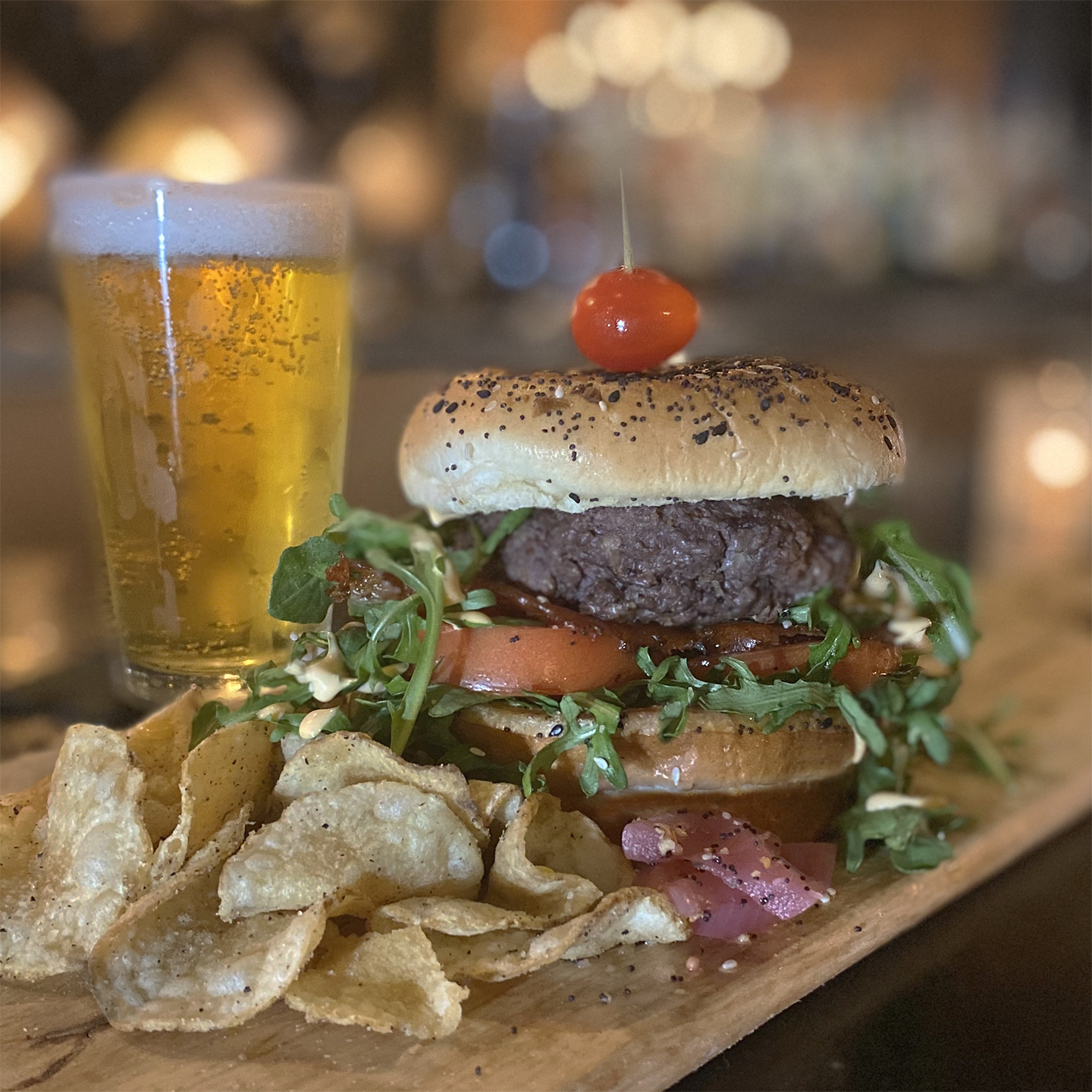 A beer and burger sitting on bartop