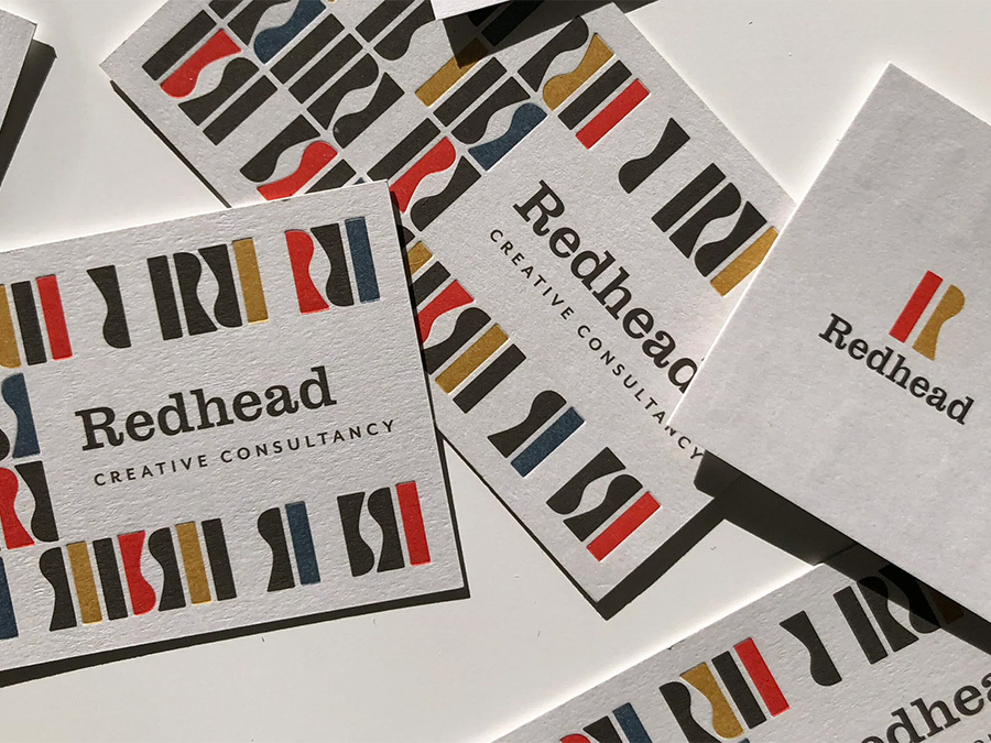 Redhead Creative Consultancy business cards on a table