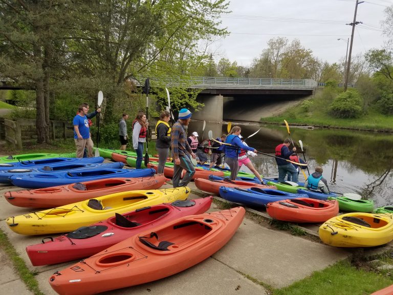 Kayaks lined up on the shore of the river