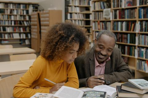 Two people reading a book together