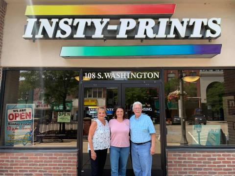 Employees posing in front of store